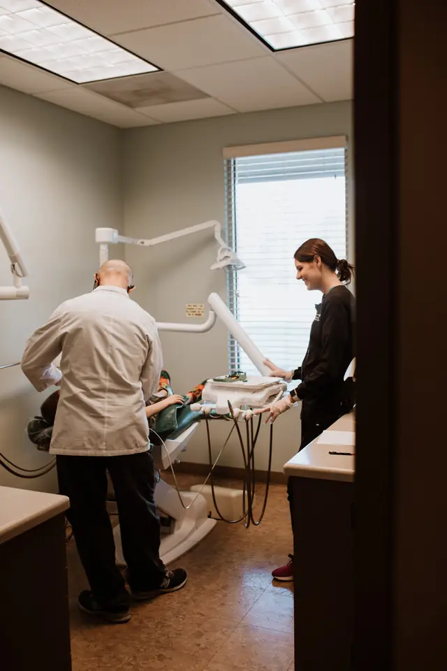 A Defiance Dental Group dentist and assistant working together over a patient